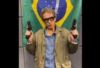 Roberto Jefferson com armas e a bandeira do Brasil ao fundo | Divulgação
