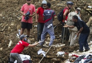 Bombeiros, moradores e voluntários trabalham no local do deslizamento no Morro da Oficina, após a chuva que castigou Petrópolis, na região serrana fluminense