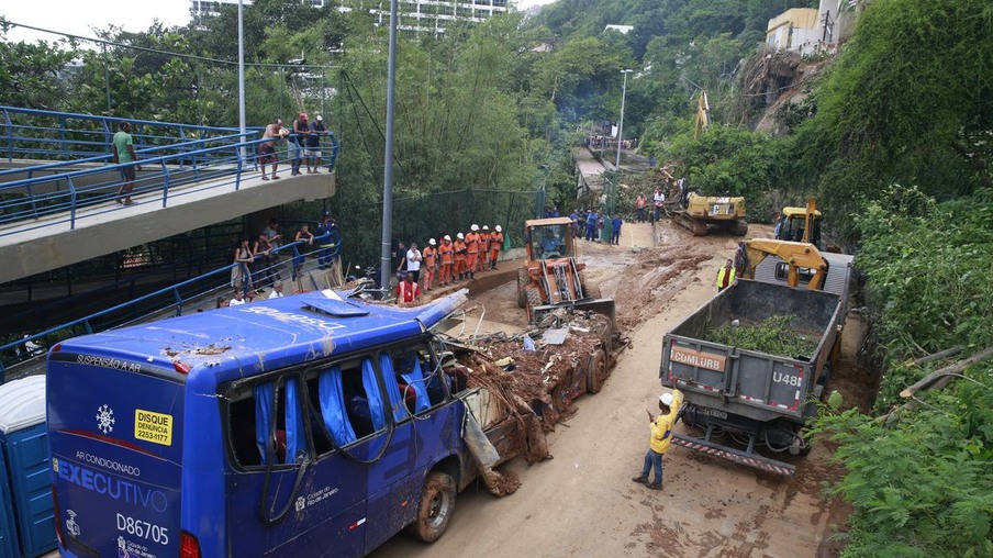 Retirada do ônibus soterrado por deslizamento de terra e árvores na Avenida Niemeyer, em São Conrado.