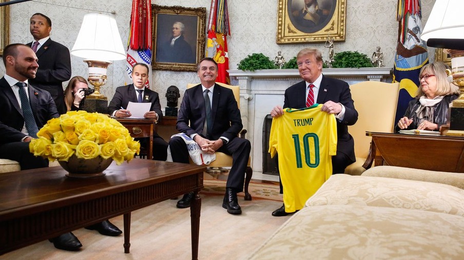 O presidente do Brasil, Jair Bolsonaro, dá uma camiseta da Seleção Brasileira de futebol para o presidente dos EUA, Donald Trump, durante reunião no Salão Oval da Casa Branca, em Washington (EUA).