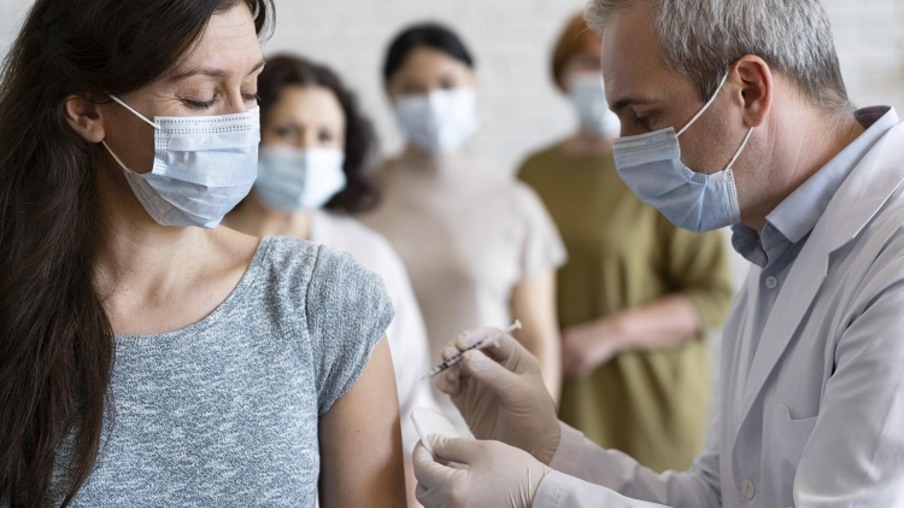 mulher recebendo vacina vacinada por medico com mascara medica